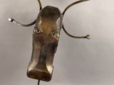 sculpture en bronze représentant une tête de taureau avec des cornes, posée sur un socle en bois