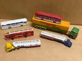 cinq types différents de bus et de camions miniatures posés sur la table