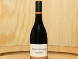 une bouteille de vin posée sur un tonneau