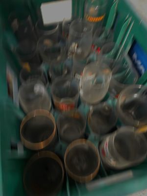 un bac vert rempli de verres vides posé sur un comptoir