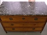 a wooden dresser with a marble top in a room