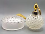 un flacon de parfum en verre muni d'une poignée dorée et un pot en verre avec un couvercle