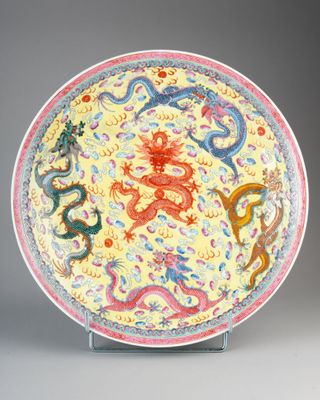 an image of a yellow and red plate with dragon designs on it