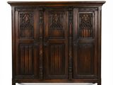 une vieille armoire en bois avec des portes sculptées et une poignée de porte