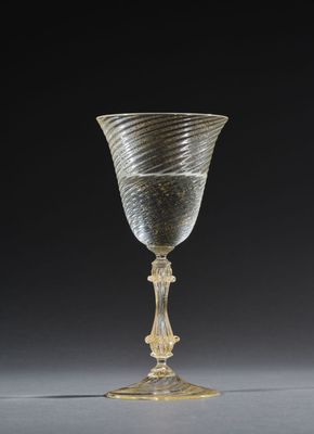a close up of a glass cup on a table with a black background