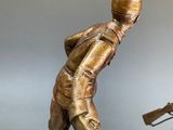 statue of a man with a gun and a rifle on a table