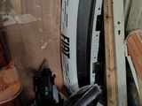 une camionnette blanche qui est garée au milieu d'un tas de ferraille