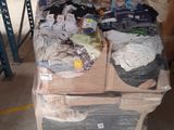 un gros tas de vêtements posé sur une palette dans un entrepôt