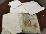 une table sur laquelle sont posés plusieurs nappes et serviettes