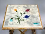 two small tables with flowers painted on them sitting next to each other