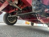 vue du dessous d'une moto rouge garée sur le bord de la route