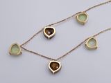 a close up of a necklace with a heart shaped pendant on it