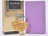 perfume bottle in front of a purple box next to a purple box