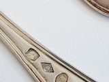 two spoons and a fork on a white table