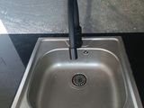 a stainless steel sink with a black faucet in it