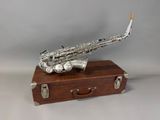 a silver saxophone sitting on top of a wooden box