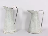 two white pitchers sitting next to each other on a table