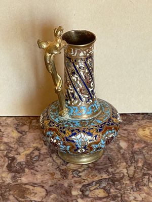un vase bleu et or posé sur une table en marbre