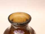 a brown vase with a pink flower on it