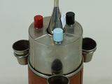une cafetière argentée et marron posée sur un socle en bois