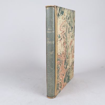 un vieux livre posé sur une table à côté d'un mur blanc