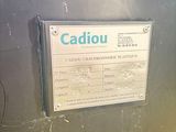 une pancarte sur la porte d'un immeuble où l'on peut lire « Cadiou »