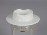 a white cup and saucer sitting on a clear table