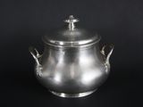 an antique silver teapot with a lid on a black background