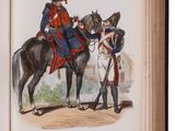 a hand holding an open book with a picture of a man on a horse
