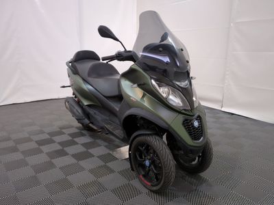 un scooter garé sur un sol à damier