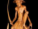 wooden statue of a man with a bow and a dog