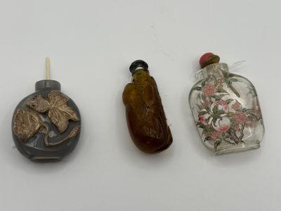 three small glass bottles sitting next to each other on a table