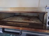 a small oven that has a dirty pan inside of it