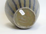 a blue and white vase with a tag on it