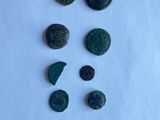 a close up of a group of ancient roman coins on a white surface