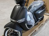 un scooter posé sur un chariot dans un entrepôt