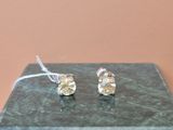 boucles d'oreilles à tige plaquées argent, ornées de cristaux transparents, présentées sur un socle en marbre