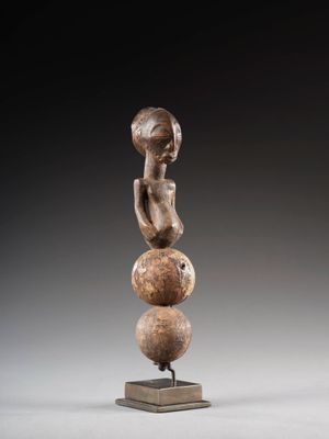une image représentant une sculpture d'une femme assise sur une boule