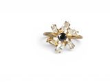a close up of a gold ring with a black and white diamond