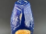a close up of a blue vase with a yellow flower