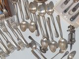 a lot of silver spoons and spoon knives on the table