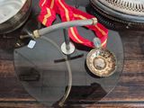 a glass table with a medal and a red ribbon on it