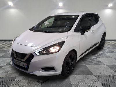 l'avant d'une Nissan Micna blanche garée sur un sol à damier