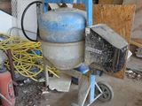 une bétonnière dans un garage rempli d'outils