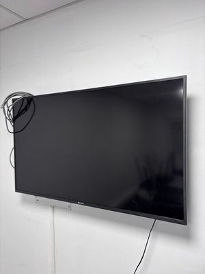 un téléviseur à écran plat fixé au mur d'une pièce