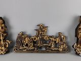 trois figurines en or représentant des personnes et des animaux, posées sur une table