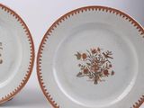 two plates with brown and white designs on them on a white surface