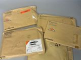 trois paquets de courrier empilés les uns sur les autres sur une table