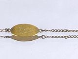 bracelet en argent orné d'une pierre jaune suspendue à une chaîne, sur fond blanc