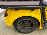 a yellow golf cart with a bag on the back of it